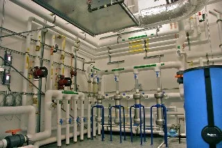 Neatly piped mechanical room with boilers, circulators and an expansion tank